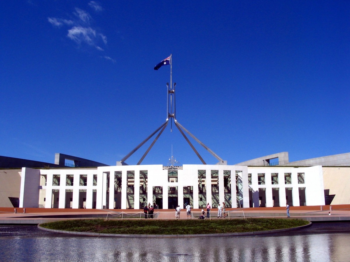 Canberra's Parliament House, a white building with a big flagpole on top carrying the Australian flag.