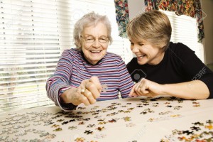 6271430-Elderly-woman-and-a-younger-woman-work-on-a-jigsaw-puzzle-Horizontal-shot--Stock-Photo