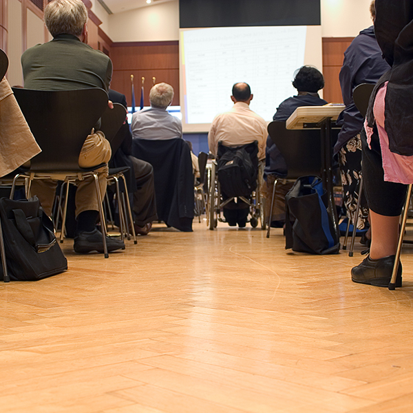 A group of people sitting in an auditorium for a conference.