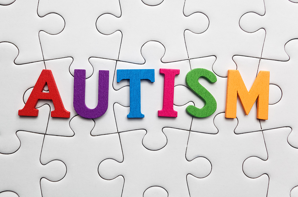 Autism inscription on a white puzzle background. Symbol of autism.