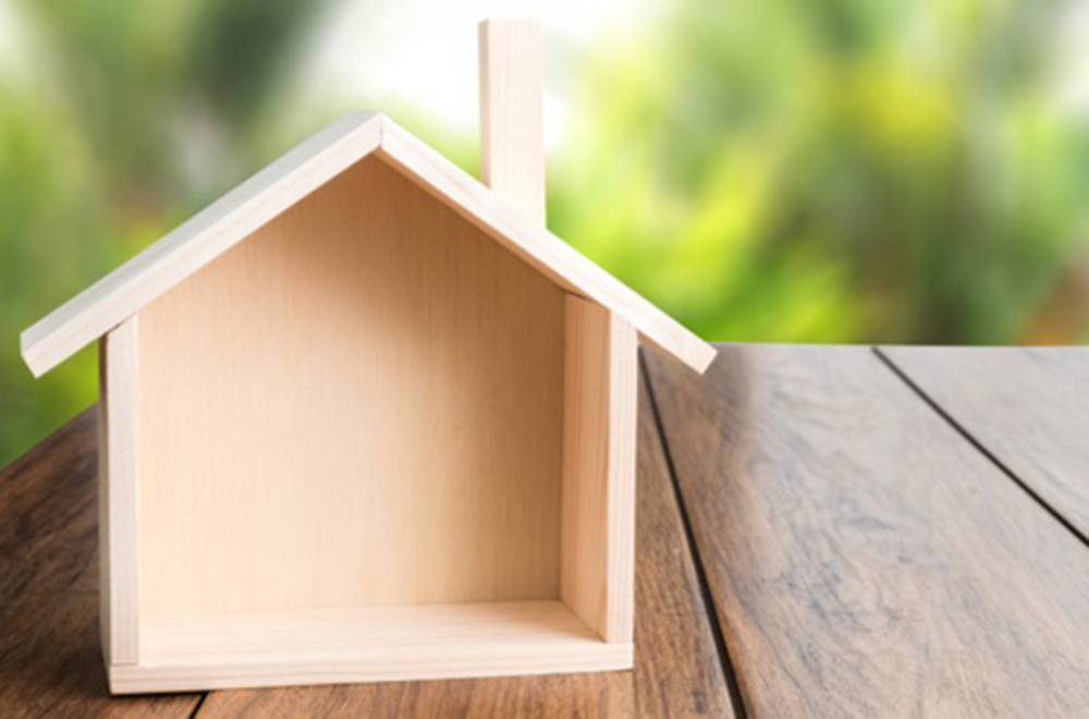 A plain mini wooden house on a decking.