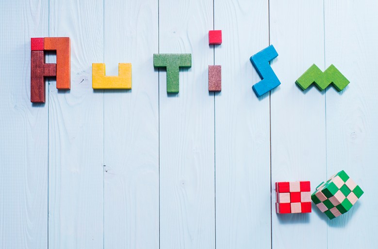 The word 'autism' spelt in colourful blocks on a blue background.