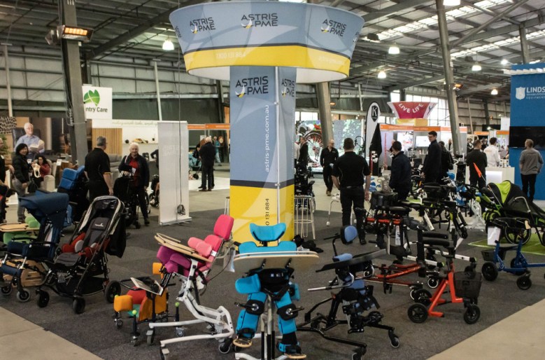 A stand at a trade show featuring multiple types of wheelchair.