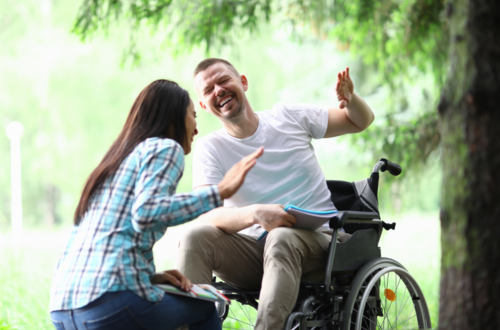 Male disabled man with girlfriend smiling on park walk portrait. Social disabitity adaptacion concept
