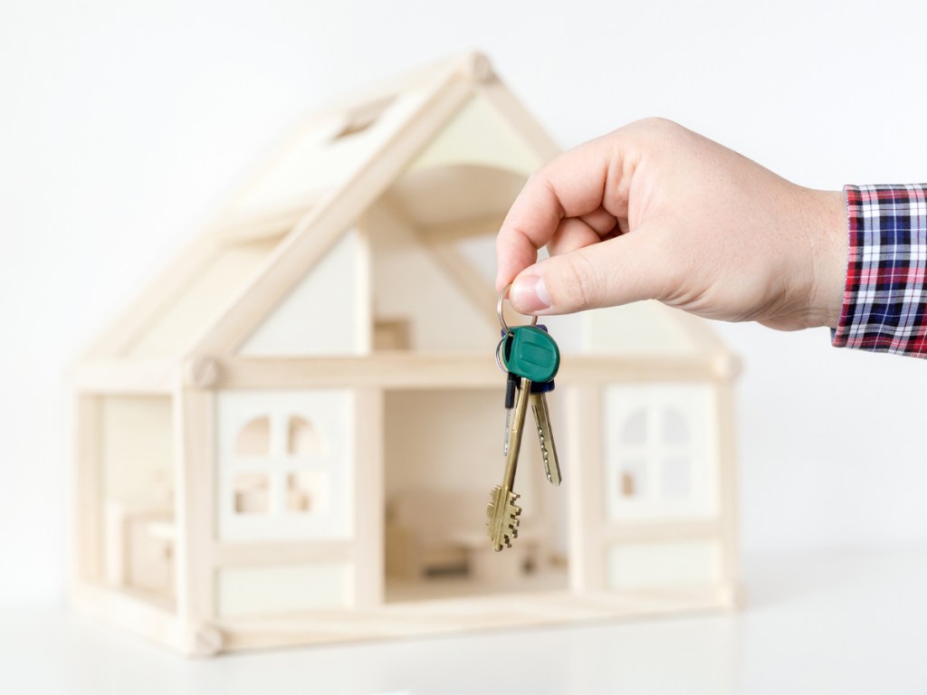 Businessman's hand giving key from new house.  Real estate for rent.  Big deal offer. Special proposition and easy terms concept.