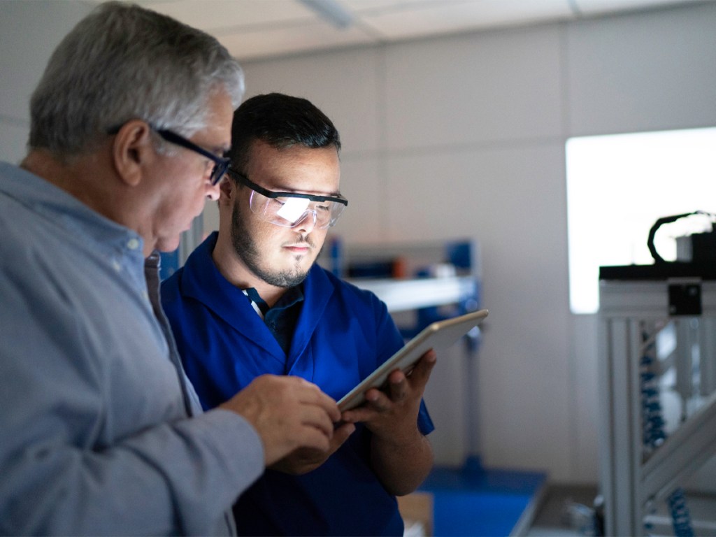 Colleagues using digital tablet and working in industry