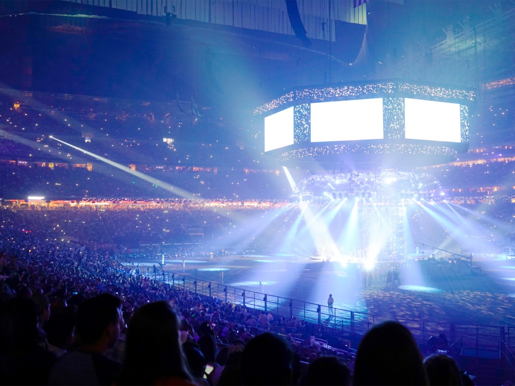 Concert stage with shining lights and crowd at a performance. Ro