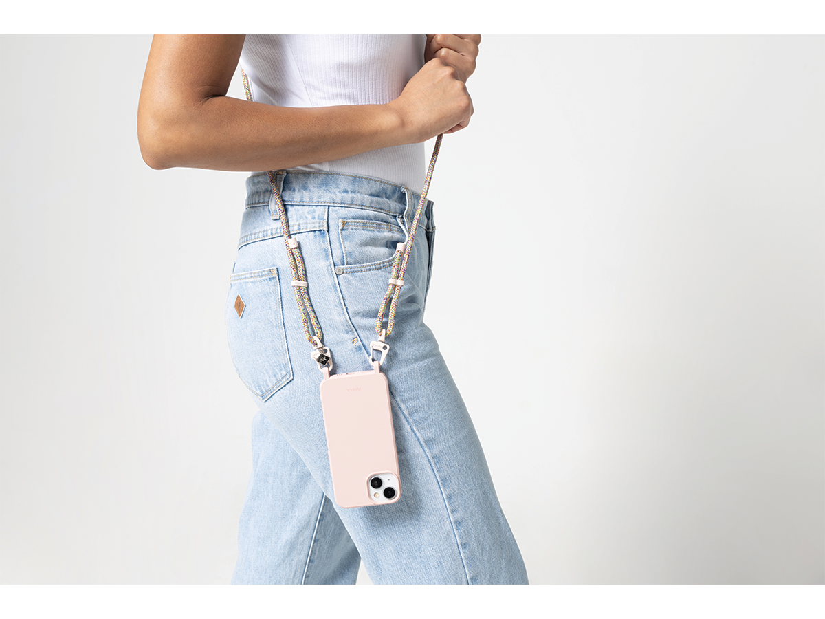 A person models a RIKKA strap on their smartphone, which is hanging at their side on a strap. We can see their legs. They are wearing blue jeans.