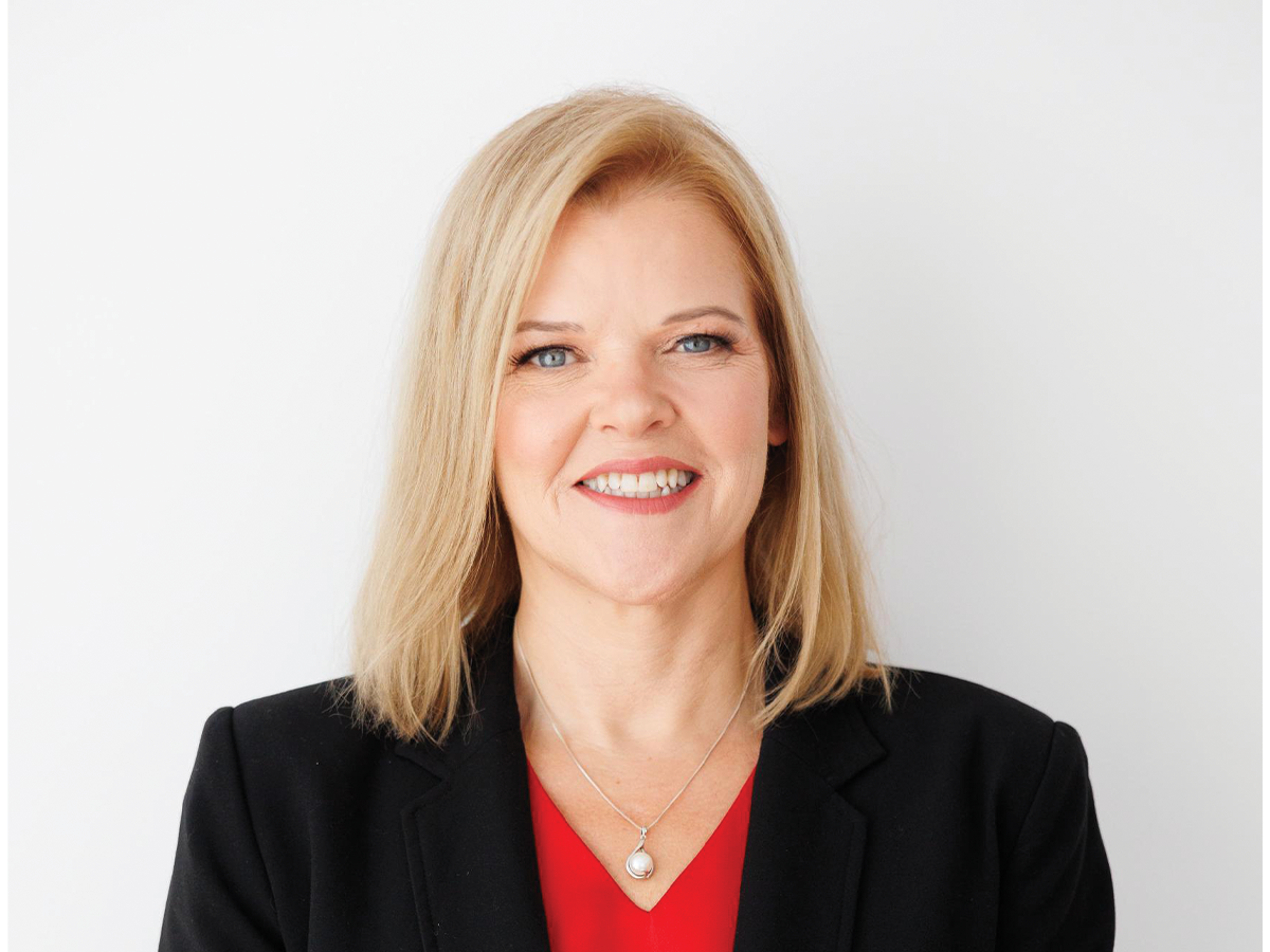 NOFASD CEO Sophie Harrington, a blonde lady in a black blazer and red top, smiles at the camera. We see her from the shoulders up.