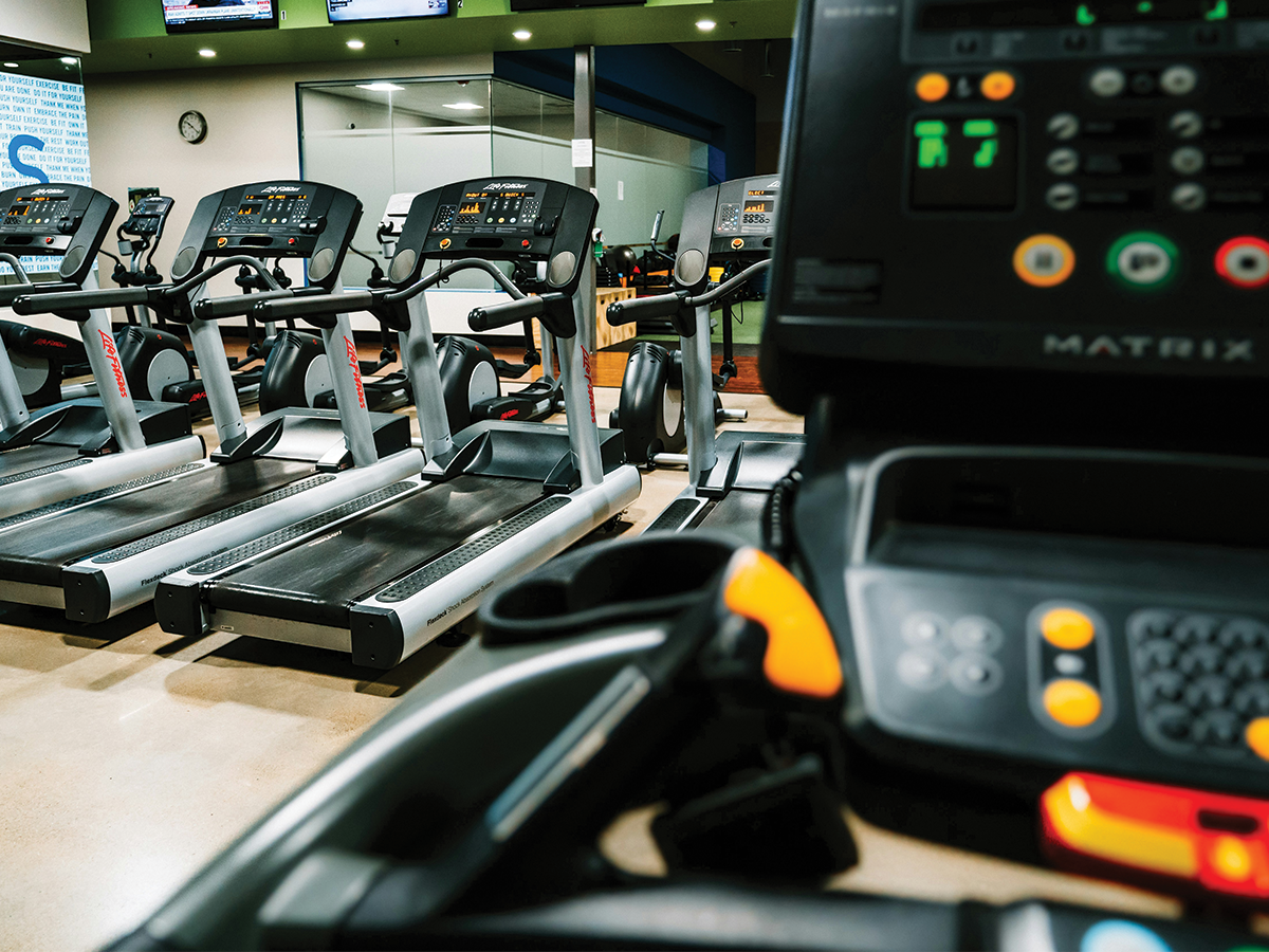 A row of treadmills at a gym, one close up.