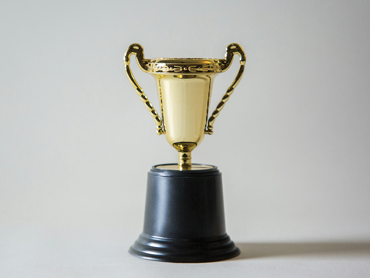 A gold trophy on a neutral background.