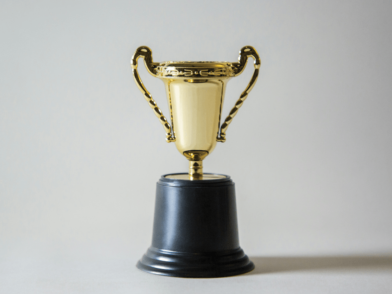A gold trophy on a neutral background.