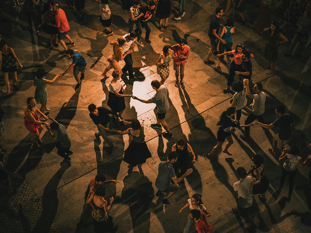 A group of people dancing in orange glowing light.