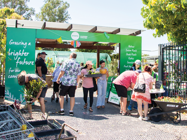 Crowds at STEPS Garden Centre, with lots of trees and a big green banner welcoming people in.