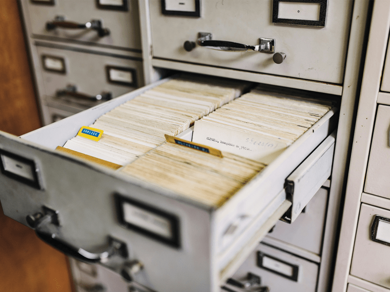 A white archive drawer pulled open so we can see the files inside.