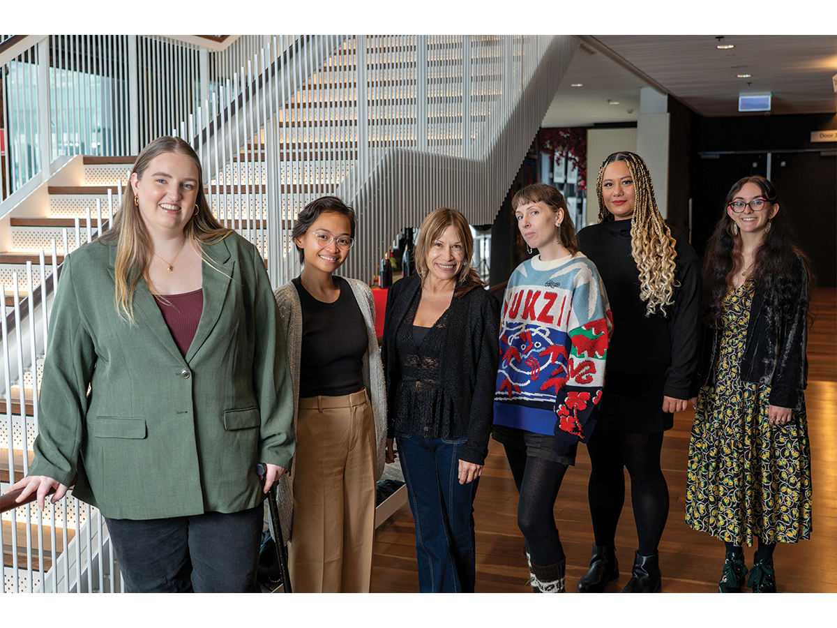 A group of young women, all dressed casually, smiling at the camera